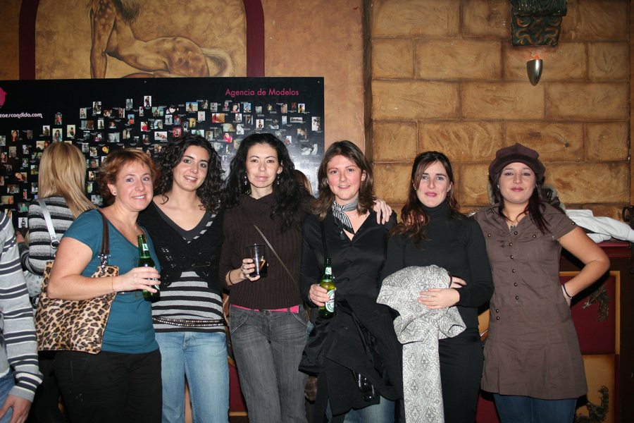 Un grupo de asistentes posando delante del panel de la agencia.